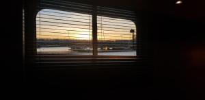 a window with a view of an airport with an airplane at KELLY'S ROOM EUPHRATE HOUSEBOAT in Amsterdam