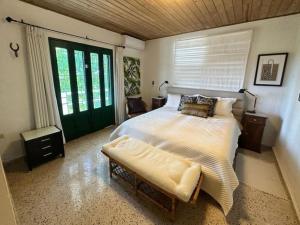 a bedroom with a large bed and a green door at KASA Finca La Limonada near Palmas Del Mar in Humacao