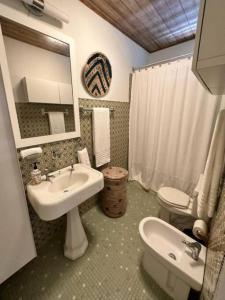 a bathroom with a sink and a toilet and a mirror at KASA Finca La Limonada near Palmas Del Mar in Humacao