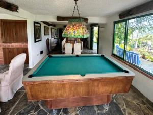 a pool table in a living room with a chandelier at KASA Finca La Limonada near Palmas Del Mar in Humacao