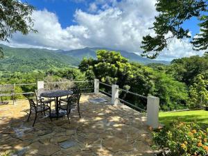 a table and chairs on a patio with a view of mountains at KASA Finca La Limonada near Palmas Del Mar in Humacao