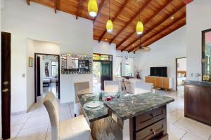 cocina y sala de estar con mesa y sillas en Casa Las Lajas, en Esterillos