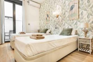 a bedroom with two beds and a wall of wallpaper at 3BR apartment with community pool, parking and patio - Center by REMS in Málaga