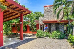 uma casa com uma bandeira em frente em Casa Las Lajas em Esterillos