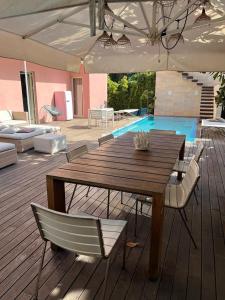 a wooden table and chairs on a deck with a pool at Villa Olimpia in Mondello