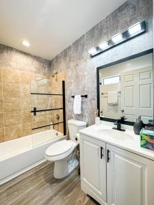 a bathroom with a white toilet and a sink and a tub at Modern Friendly 3BR Habitat - WO - BUR in Burbank