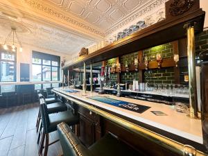 a bar in a restaurant with a counter and chairs at The Valley Inn Liverpool in Liverpool