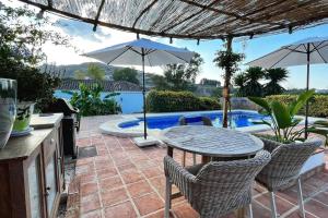 een terras met een tafel en stoelen en een zwembad bij La Sureña in Alhaurín el Grande +16 foto's