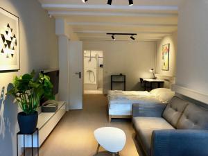 a living room with a couch and a bed at The Suites Alster Waterfront Family Apartments in Hamburg