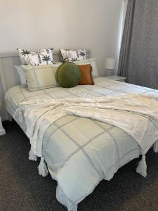 een slaapkamer met een groot bed met kussens bij Stay at 66 - Luxury Family Home - Pet Friendly in Goolwa South