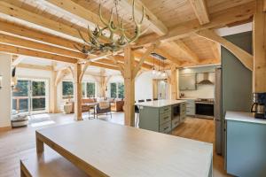 uma cozinha e sala de estar com tectos em madeira e uma mesa em Black Rock Lodge em Stowe