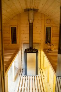 an inside view of a wooden cabin with a stove at Domki trzy jeziora z zewnętrznym SPA - sauna, balia do schładzania i jacuzzi in Małe Swornegacie