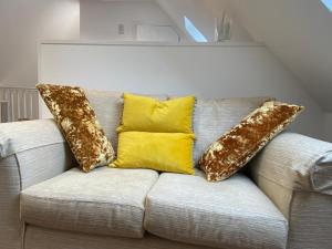 a couch with three pillows on top of it at Garden annex in Welton