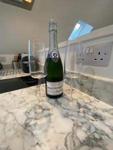 a bottle of wine and two wine glasses on a counter at Garden annex in Welton