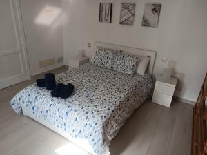 ein Schlafzimmer mit einem Bett mit zwei Schuhen drauf in der Unterkunft Casa Celia in Valsequillo de Gran Canaria