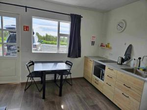 a kitchen with a table and a sink and a counter at Apartment Skógafoss in Skogar