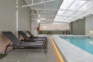 uma piscina com espreguiçadeiras ao lado de uma piscina em Hotel Pires em Balneário Camboriú