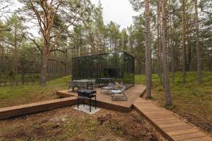 a glass house in the middle of a forest at ÖÖD Hötels Lohusalu LEIDA & ENNO in Laulasmaa