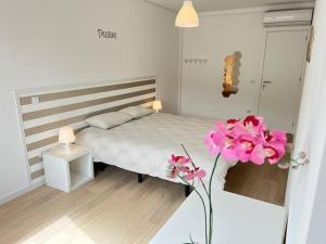 a small bedroom with a bed and pink flowers at HEART OF THE CITY 10 ! in Porto
