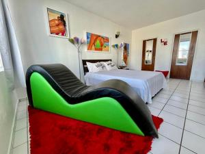 a bedroom with a bed with a green couch in it at Condado Beachfront Tantra Apartment in San Juan