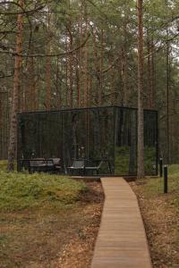a glass building in the middle of a forest at ÖÖD Hötels Lohusalu LEIDA & ENNO in Laulasmaa
