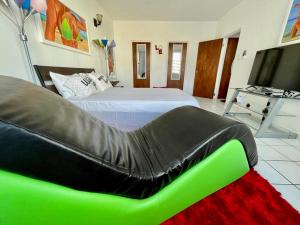 a bedroom with a bed and a green couch at Condado Beachfront Tantra Apartment in San Juan