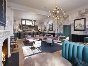 restauracja ze stołami i krzesłami oraz kominkiem w obiekcie Bailiffgate Hotel w mieście Alnwick