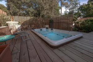 a hot tub on a deck with a table and a chair at Villa A Nouste à Arcachon in Arcachon