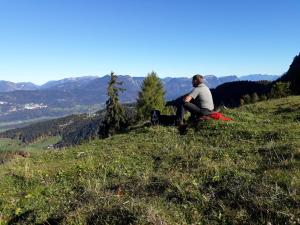 Ein Mann auf einem Grashügel in der Unterkunft Haus Gmahblick Appartments in Alpbach