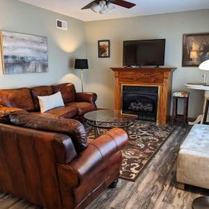 a living room with a leather couch and a fireplace at Georges on York B&B in Taneytown