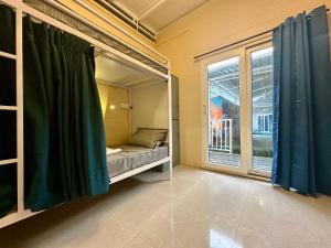 a room with a bed and a large window at Coco Hostel Goa in Palolem