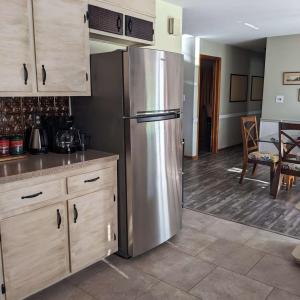 a stainless steel refrigerator in a kitchen with a table at Georges on York B&B in Taneytown