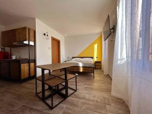 a bedroom with a bed and a table in a room at La Volpe Rossa Rooms and Apartments in San Felice del Benaco