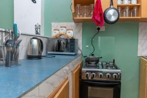 a kitchen with a stove and a microwave at Meraki home 3 in Kampala