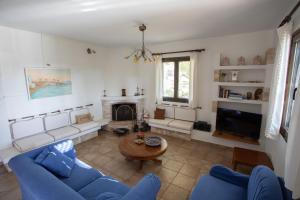 a living room with a blue couch and a fireplace at Villa Sounio in Sounio