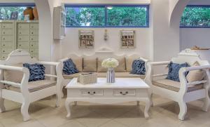 a living room with two chairs and a couch and a table at Hotel Nathalie in Ixia