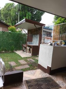 a patio with a table and a bench in a yard at FAST Wifi 400 Mbps Tiny House in Bacolod City in Bacolod