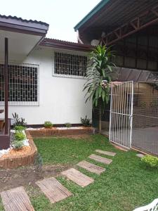 a yard with a gate in front of a house at FAST Wifi 400 Mbps Tiny House in Bacolod City in Bacolod