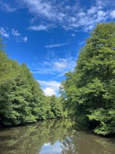 a river with trees on the side of it at Glamping Calvados 