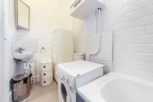 baño blanco con lavadora y lavamanos en Unique 1 BR flat btw Hammersmith & Fulham, en Londres