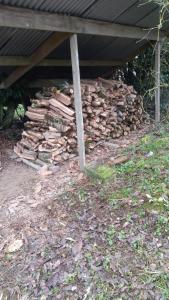 a pile of fire wood under a roof at Glamping Calvados 