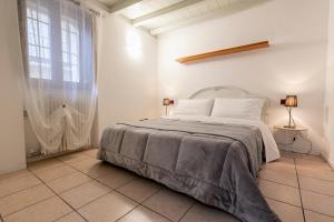 a white bedroom with a bed and a window at Sweet House a Veronetta - A pochi metri dal Centro in Verona