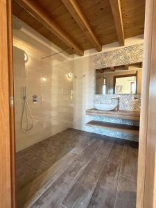 a bathroom with a tub and a sink and a mirror at La Volpe Rossa Rooms and Apartments in San Felice del Benaco