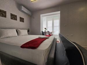 een slaapkamer met een groot bed met een rode deken erop bij Tiny Rose Studio in Tirana