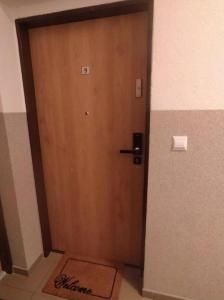 a wooden door in a room with a mat in front of it at Apartament Mała Ogrodowa in Oborniki Śląskie