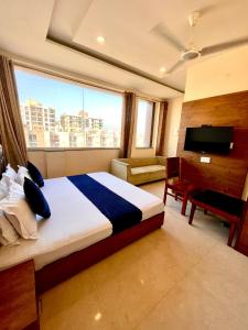 a hotel room with a bed and a tv and a bedroom at Hotel Woodcrest Zirakpur Chandigarh- Best Family Hotel in Chandīgarh