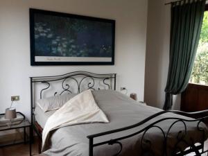 1 dormitorio con 1 cama y una foto en la pared en Guest House Brera vicino aeroporto di MXP e laghi, en Varallo Pombia