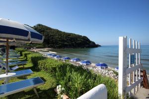 a row of beach chairs with umbrellas and the ocean at Dimora del Leone Gaeta in Gaeta