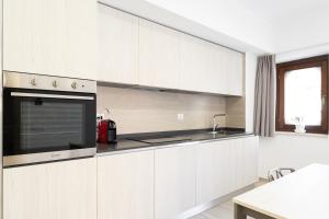 La cuisine est équipée de placards blancs, d'un évier et d'un four micro-ondes. dans l'établissement Appartamento comfort-relax, à Termoli