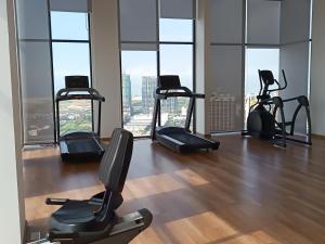 a gym with cardio equipment in a building with windows at Sky InfinityPool 2R2B 2-6pax 5minJonker Malacca in Melaka